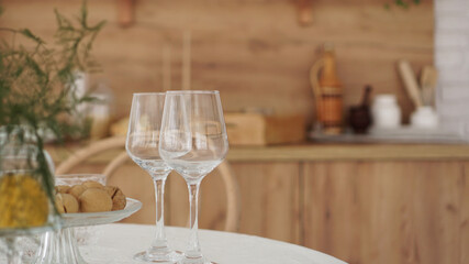 Empty wine glasses on wooden interior of modern kitchen. Scandinavian style, rustic style in warm brown tones