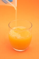 Freshly squeezed orange juice with orange background