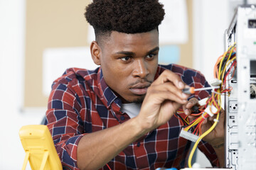 male technician working on wiring a computer