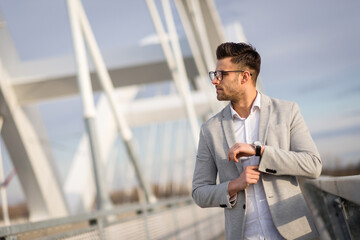 Young businessman crossing the bridge. Yuppie outdoors relaxing