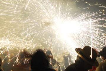 People playing with pyrotechnics in the street at a village. People having fun