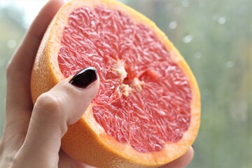 half of grapefruit in hand
