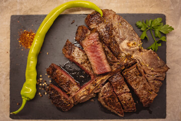 Top view of medium roasted t-bone steak. Delicious T-Bone Steak Medium Roasted with Herbs and...