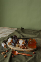 Set for Tea drinking. Various sweets, nuts and honey for tea on a wooden cutting board. Walnuts, almonds, hazelnuts, dates, rahatlukum, honey, dried fruits. Healthy sweets, natural sweets.