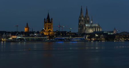 Fototapeta premium abendliches Rheinpanorama in Köln bei Hochwasser mit Kölner Dom und Großsankt Martin