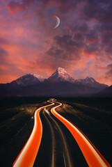Taillights on road leading to mountains at sunset