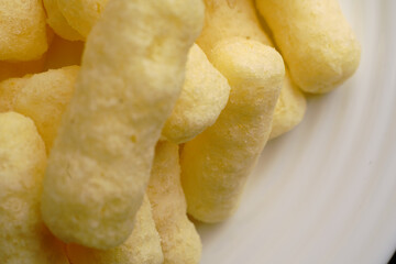 Corn sweet sticks very close on a white plate. Golden color.