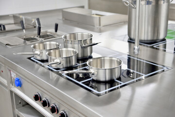 Stainless steel pots built on the stove in the restaurant kitchen