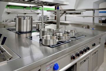 Stainless steel pots built on the stove in the restaurant kitchen