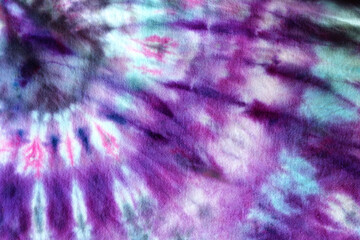 
A classic spiral of pink, purple, blue, and black ink on a tie dye shirt.