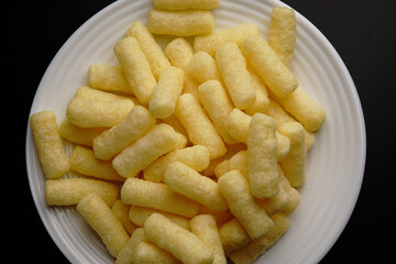 Corn sweet sticks on a white plate top view. Golden color.