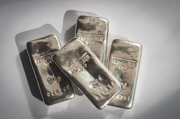 Four cast silver bars on a gray background. feinsilber is fine silver.