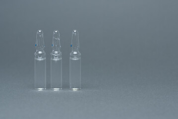 Three medical ampoule on a gray background. Medicines concept