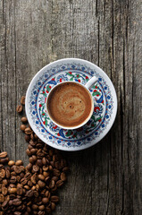 Turkish coffee concept, cup of coffee with coffee beans on wooden background