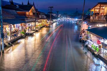 AMPHAWA, THAILAND - DECEMBER 15, 2019: Thailand people sell goods in the famous floating market at night, long exposure