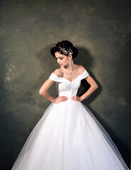 Attractive young woman in a white dress with jewelry in her hair. Beautiful bride with wedding makeup and fashion hairstyle