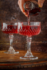 Pouring glass of red wine from a bottle.