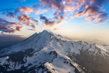 Dramatic Aerial Landscape View of the cloud covered mountains during a vibrant sunset. Artistic Render. Taken near Mount Baker, East of Vancouver and Seattle, Washington, United States.