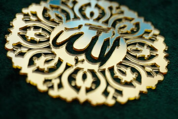 Photo of Arabic word Allah meaning The Absolute God embossed in a decorative pattern.