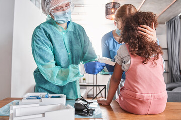 Doctor measuring temperature of girl with infrared thermometer