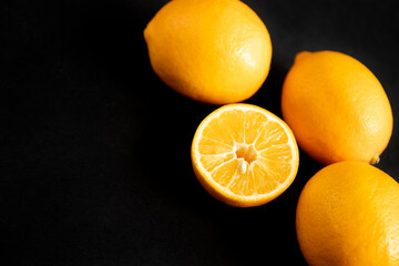Ripe juicy yellow lemons on a black background.
