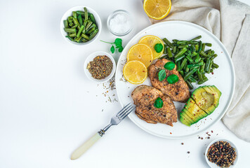 Diet breakfast with vegetables, chicken and avocado in a flat plate on a white background. Top view, horizontal. The concept of proper nutrition.