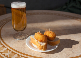 Spanish pincho of croquettes close to glass of beer