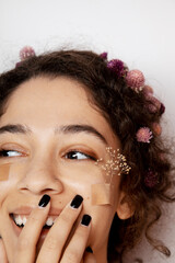 Girl with curly hair and wildflowers under her eyes