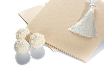 Beautiful of white chocolate ball shaped candies with filling, nuts and coconut  flakes lie on a...