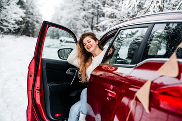 Car travel. A girl in a red car, winter travel