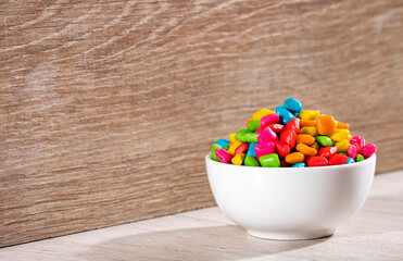 Mini colored chewing gums in the bowl - Text space