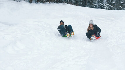 Fototapeta na wymiar Happy young multiracial couple sliding on snow. Winter sports. High quality photo