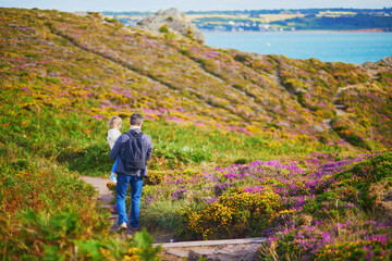 Man and toddler girl walking in heather meadows on Cape d'Erquy