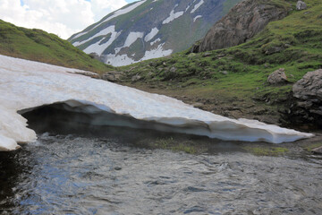 Thaw stream under glacier in the mountains