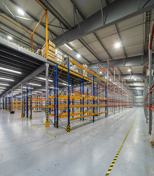 Interior of huge empty storehouse. Industrial warehouse racking.