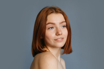 Woman with foxy short hair posing over grey background