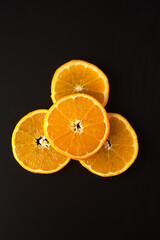 Top view of orange slices on a black background.