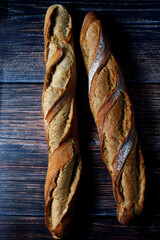 Vertical top view of baguette bread on a wooden table