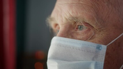 Portrait of elderly old man with short white hair, wearing face medical mask for protection virus, coronavirus covid 19. Health care concept, american grandfather grandpa senior male home near window - Powered by Adobe