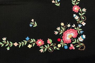 The horizontal picture of the detail of traditional norwegian vest-coast embroidery ornament, called Sand,  on the black woollen fabric