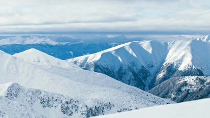 Naklejka premium Mountain peaks covered in snow on sunny winter day. High quality photo