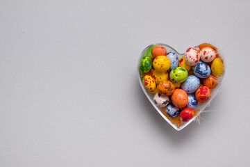 Heart shape filled with colored eggs for Easter Day with copy space