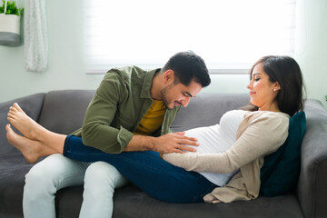 Adorable latin man touching his pregnant wife's belly