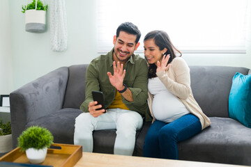 Obraz premium Parents expecting a baby talking with family during a video call