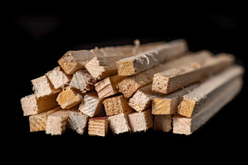 Small wooden slats with a square cross-section. Raw wood for use in a carpentry workshop.