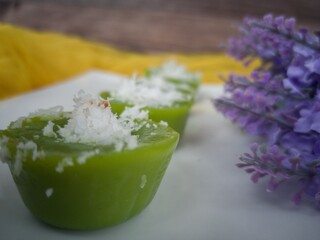 Steamed Pandan Rice Cake or locally known as Kuih Lompang or Kuih Kasui  with desiccated coconut on top. Selective focus points. Blurred background