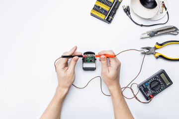 cctv camera service repair concept. above view. handyman adjusting surveillance camera using tools on white desk
