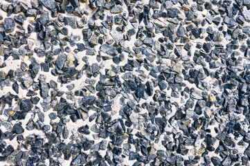 Texture of concrete wall with granite rubble close-up.