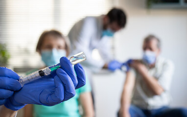 medical team giving coronavirus vaccine to seniors in vaccination center