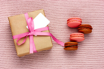 Gift box tied with a pink ribbon. A gift for a loved one. French macaroon cookies.